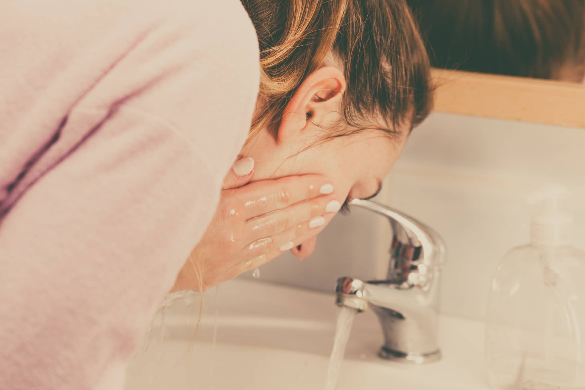 femme se lavant le visage avec la technique du double nettoyage