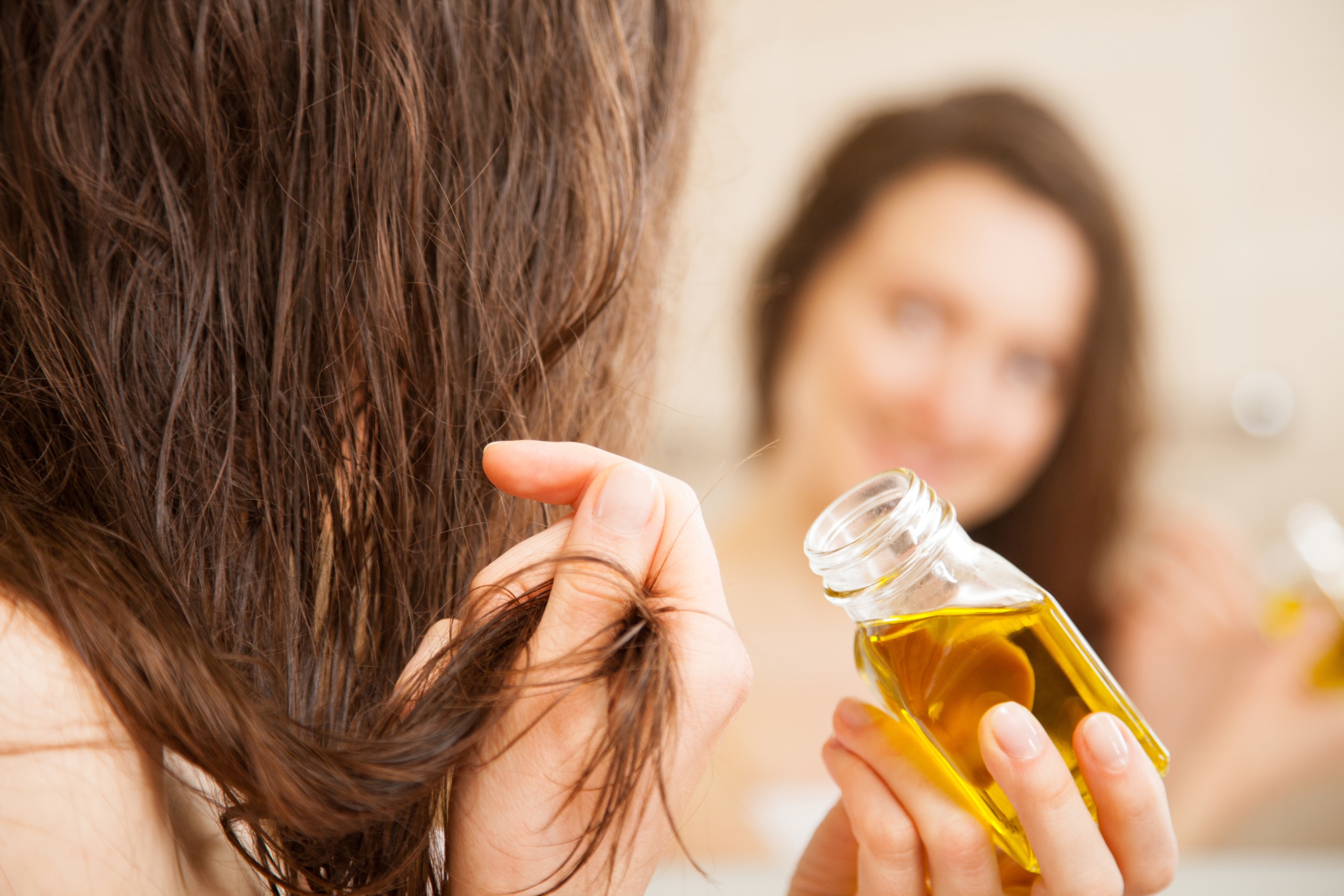 portrait d'une femme en train de faire un bain d'huile pour ses cheveux